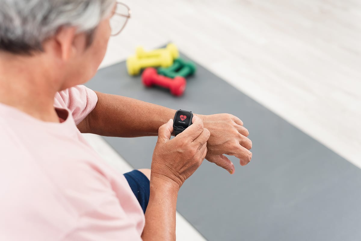 Technology and sport concept, Asian old woman View data from the smart watch. After exercise, white screen.